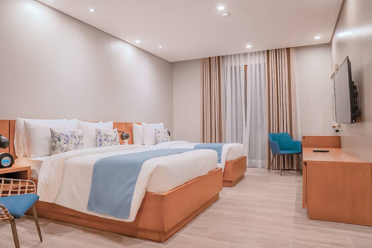 Una habitación de hotel moderna con una cama grande, un escritorio y una silla.