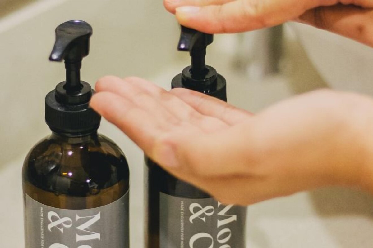 Two bottles with pump dispensers, likely containing hand sanitizer, placed on a surface.