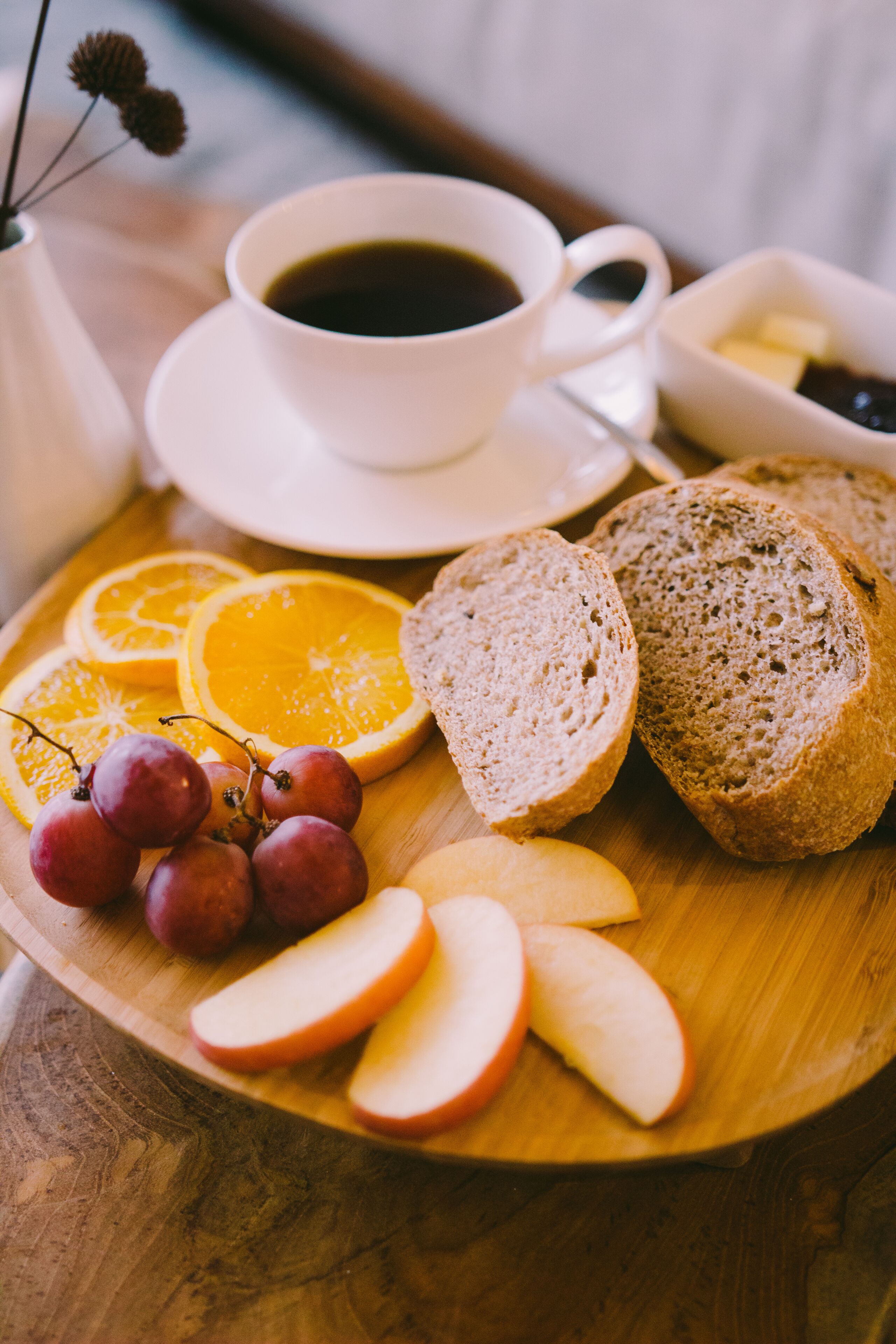 Ein Holzboden mit Apfelscheiben, Trauben, Orangenschnitten und Brot.