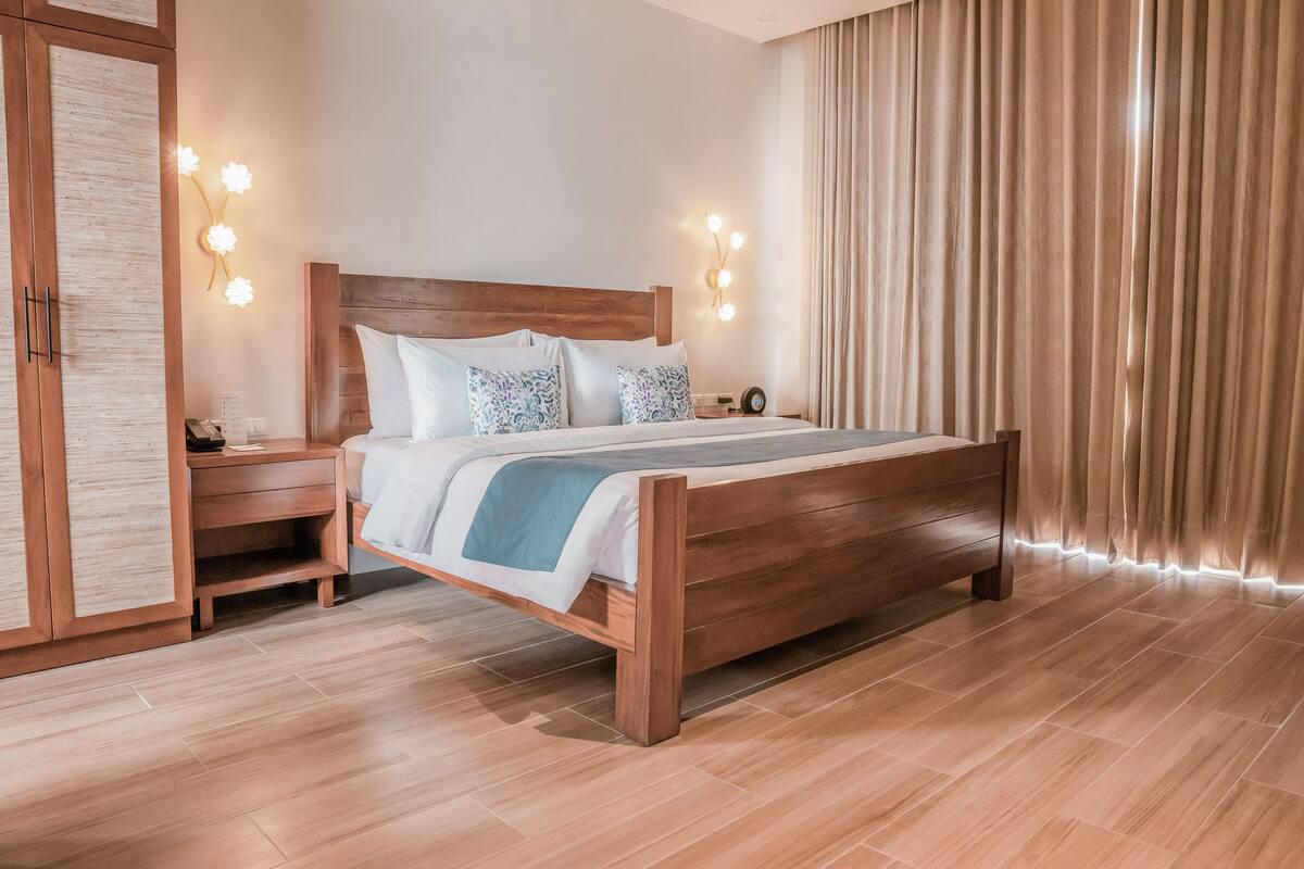 Un dormitorio moderno con una cama de madera, mesitas de noche y un armario.