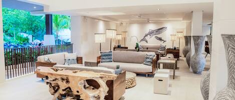A spacious living area with a large sofa, a coffee table, and a view of the outdoors.