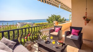 A balcony with wicker furniture, a table with drinks, and a view of the sea. - VILLA PAULA, 7 bedrooms, heated 36sqm private pool, Jacuzzi, Gym and sea views (Kastel Gomilica)