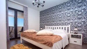 A bedroom with a bed, a nightstand, a lamp, a fluffy rug, and a patterned wallpaper. - Villa Nano - Private heated 32 sqm infinity pool, a jacuzzi, amazing sea views (Jesenice)