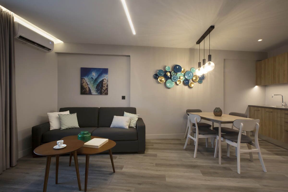 A modern living room with a sofa, coffee table, and dining area.
