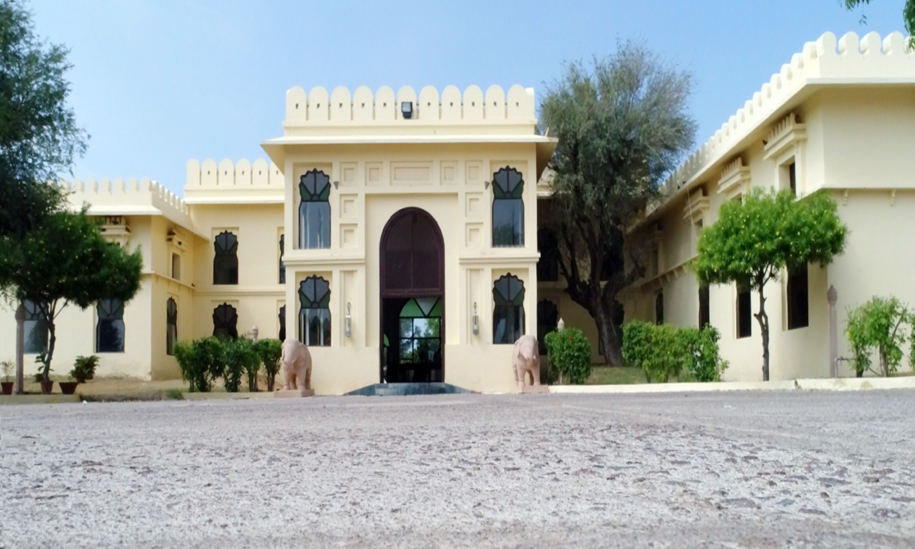 A large building with a central arched entrance, multiple windows, and a symmetrical facade.
