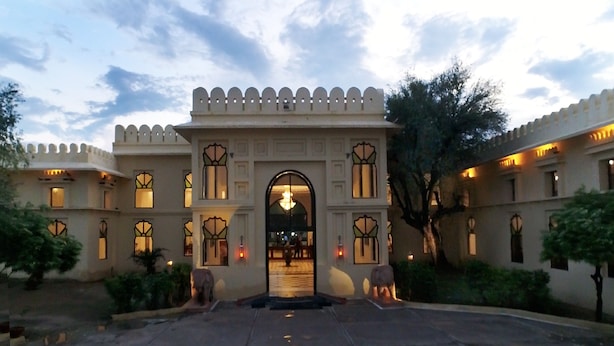 Um edifício tradicional com um arco central, várias janelas com vidros decorativos e fachada simétrica.