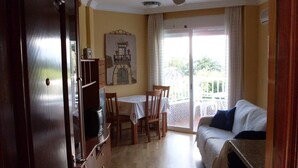 Une pièce comprenant un coin repas, un canapé et un balcon avec vue.