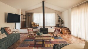 Een woonkamer met een open haard, een bank, een salontafel en een televisie.
