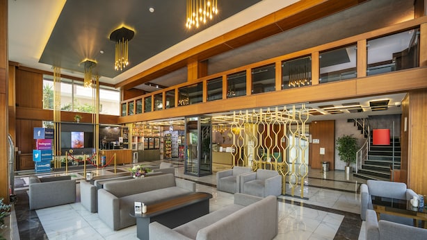A spacious lobby with modern seating, a reception desk, and a staircase leading to upper floors. - The Bostanci Hotel (Istanbul)