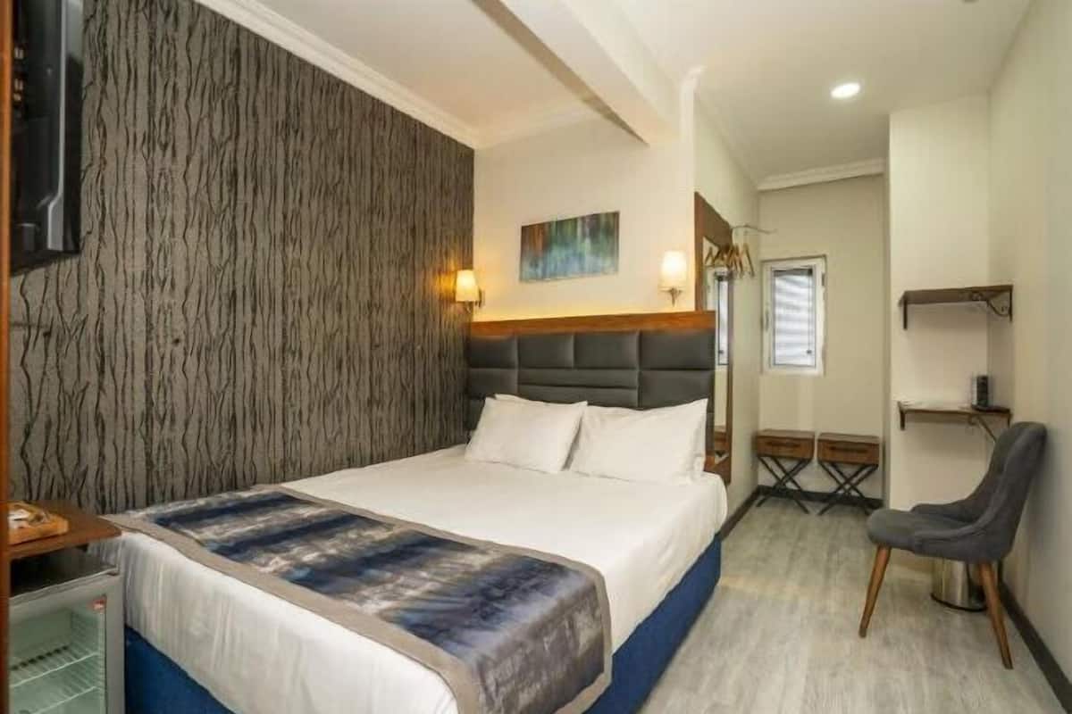 Ylelliset vuodevaatteet, tallelokero huoneessa, silitysrauta/-lauta