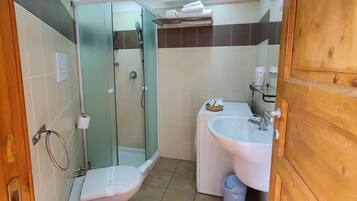 Een badkamer met twee wastafels, een douche en een toilet.