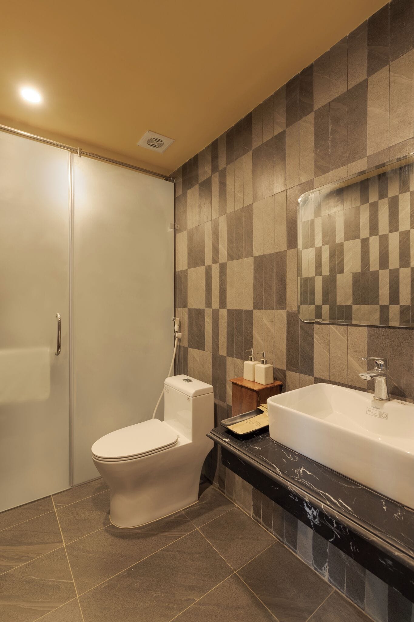A bathroom with a toilet, sink, and mirror.