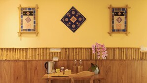 A wooden interior with a herringbone floor, a table with chairs, and decorative wall panels. - Puluong Natura Bungalow (Pu Luong)