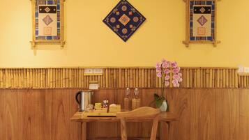 Interior de madera con suelo de espiga, una mesa con sillas y paneles decorativos en la pared.