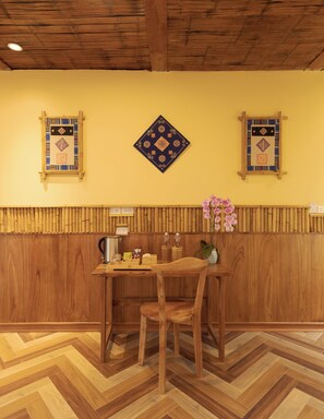 A wooden interior with a herringbone floor, a table with chairs, and decorative wall panels. - Puluong Natura Bungalow (Pu Luong)