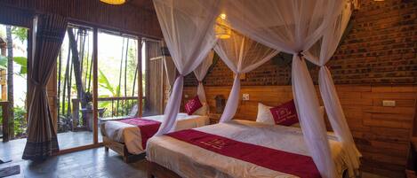 A room with two beds, each with a canopy and white bedding.