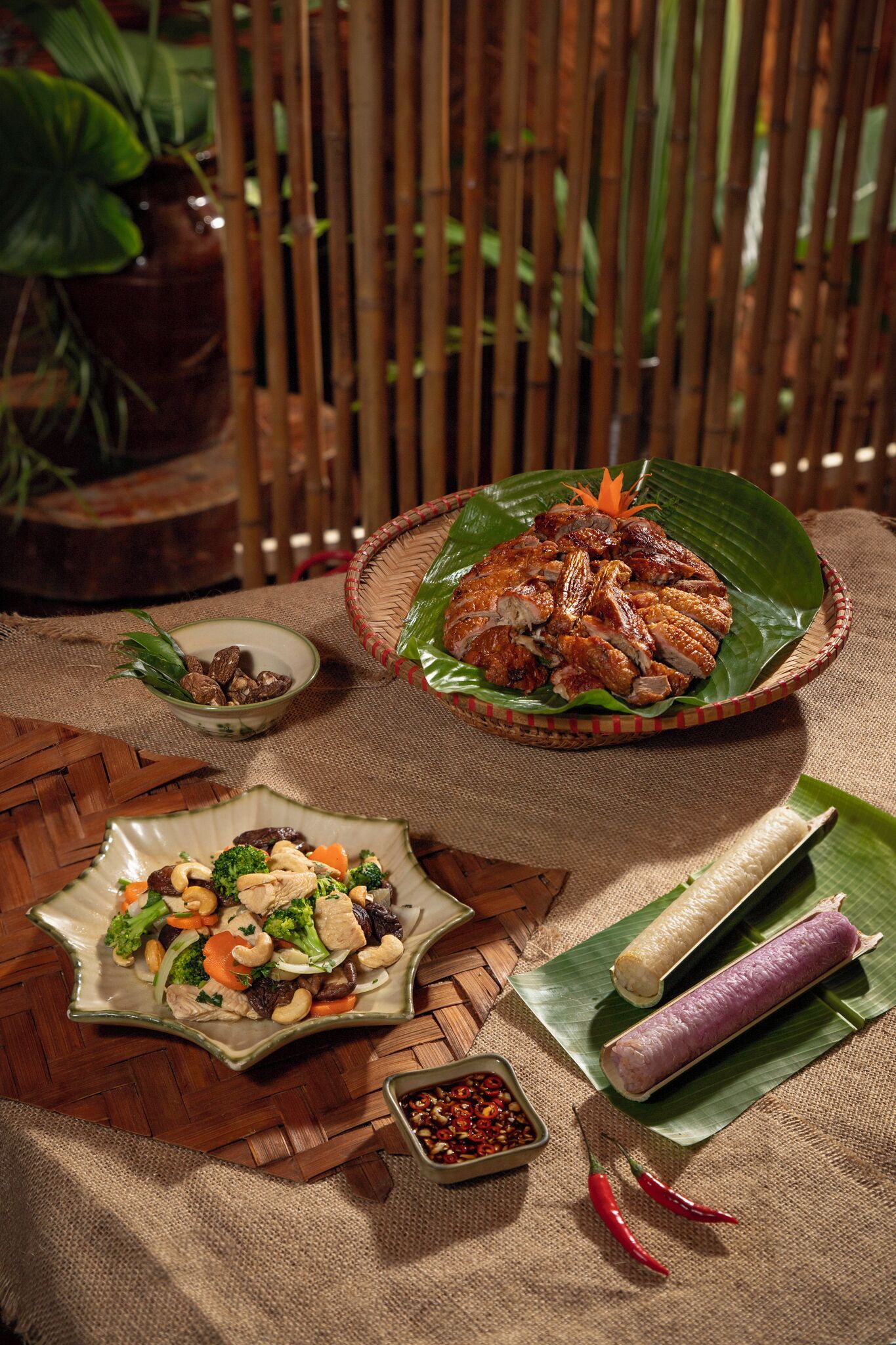 A table with a roasted meat dish, a vegetable stir-fry, and two types of rice cakes.