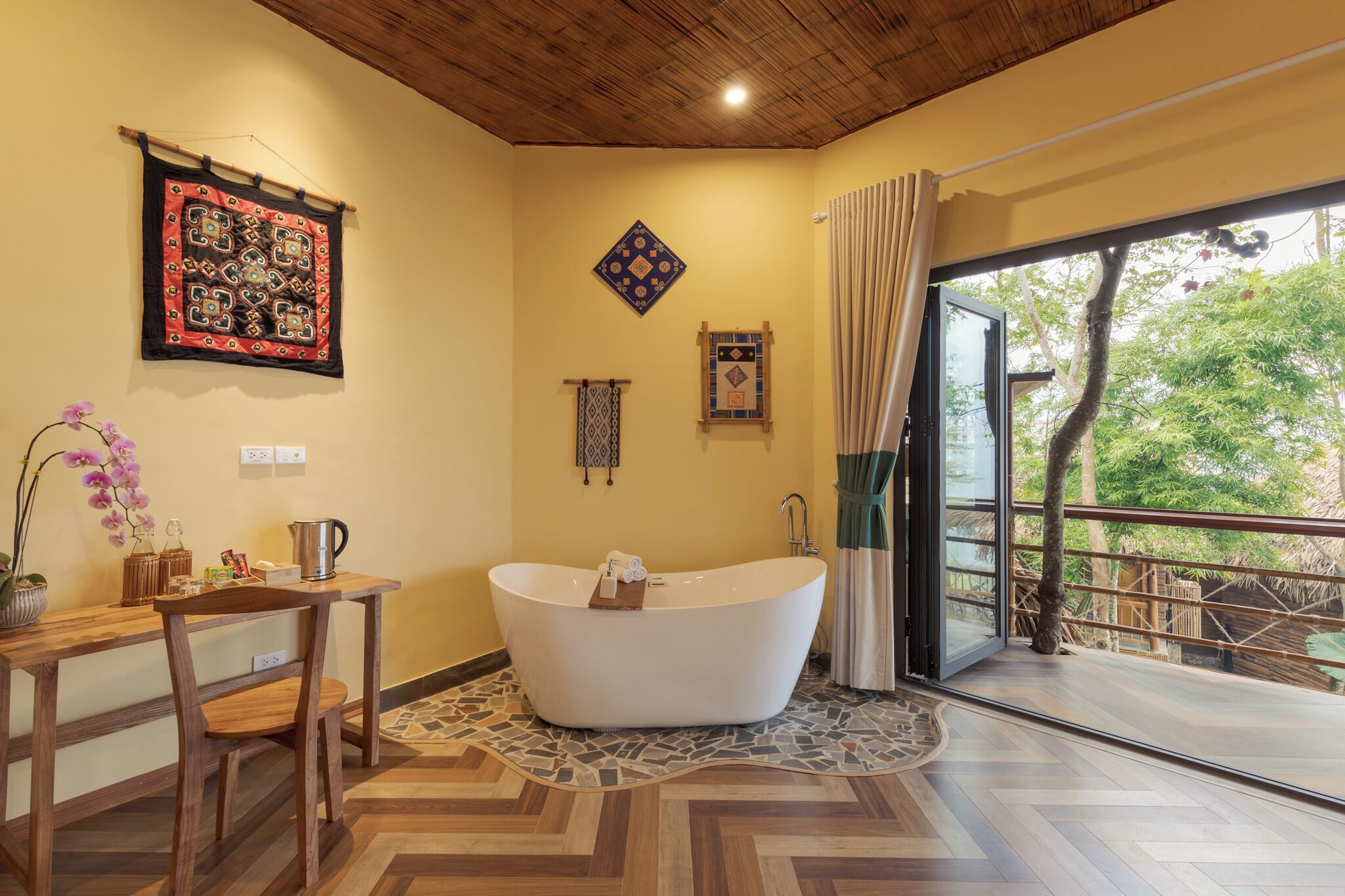 A modern bathroom with a freestanding bathtub, wooden furniture, and a view of the outdoors.