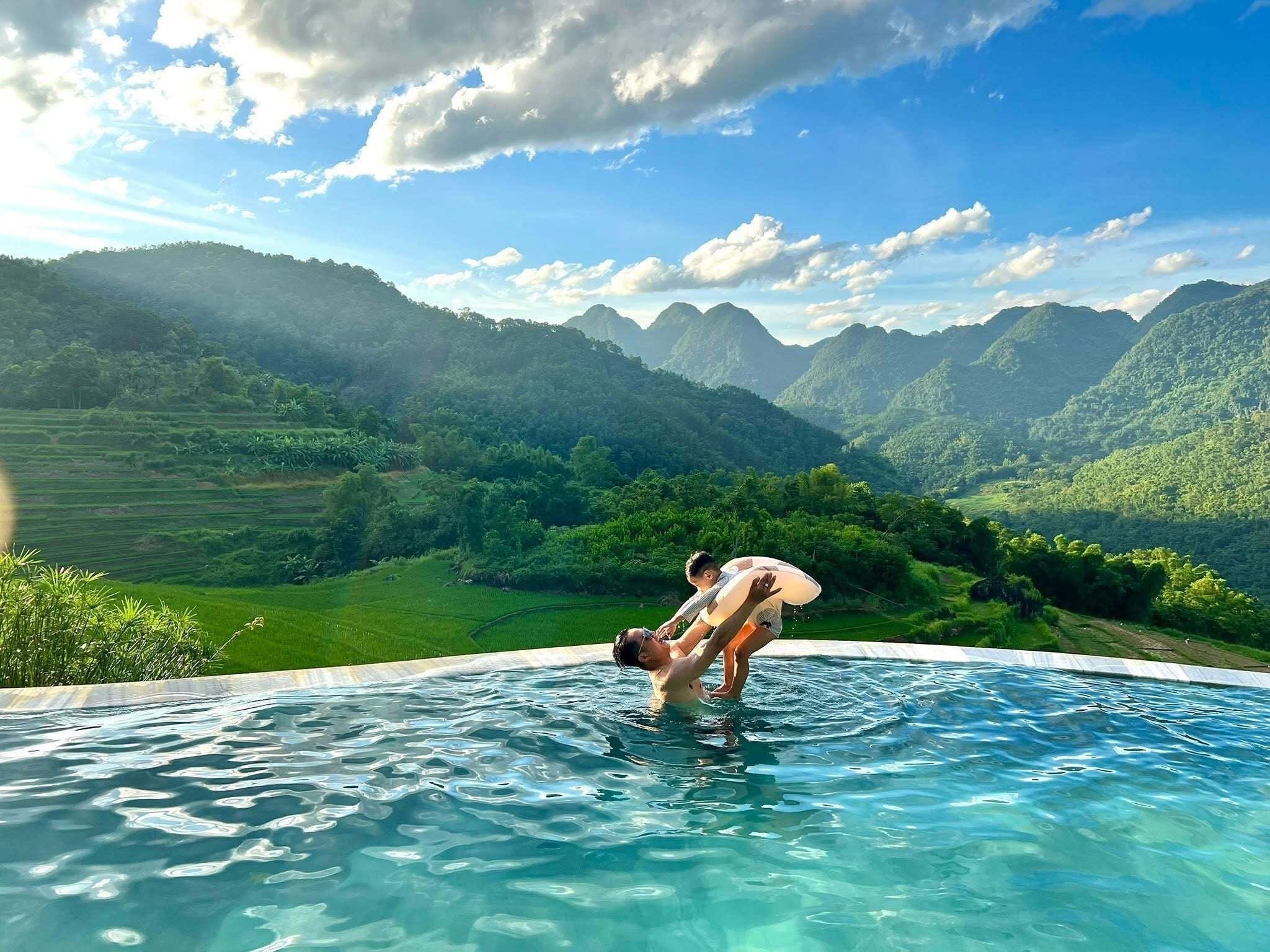 Ein Schwimmbad mit Blick auf grüne Hügel und Berge.