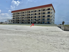 A multi-story hotel with balconies and a sandy beach in the foreground. - 116 - Oceanfront First-Floor Escape | Steps to the Sand (New Smyrna Beach)