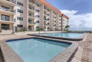 A hotel with multiple balconies, a swimming pool, and a view of the ocean. - 116 - Oceanfront Delight Ground Floor (New Smyrna Beach)