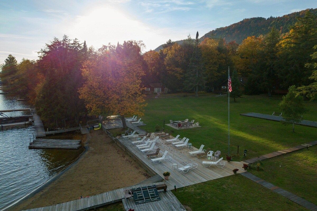 Une terrasse au bord du lac, avec des chaises longues et un mât pour drapeau.