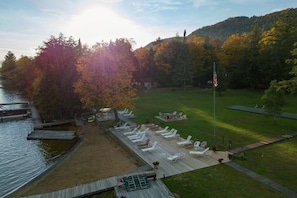 Une terrasse au bord du lac, avec des chaises longues et un mât pour drapeau.