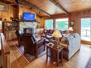 Un salon chaleureux avec une cheminée, des meubles en bois et un téléviseur.