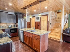 A modern kitchen with granite countertops, stainless steel appliances, and wooden cabinetry.