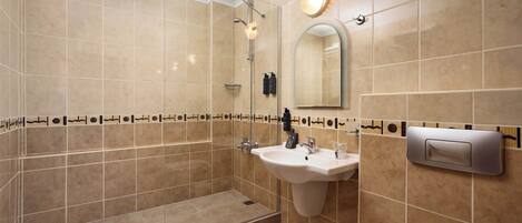 A modern bathroom with a walk-in shower, a sink with a mirror, and a toilet.