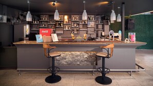 A modern bar area with a central island, bar stools, and overhead pendant lighting. - Kaila City Hotel (Alanya)