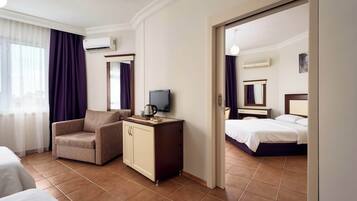 Une chambre d’hôtel équipée d’un lit, d’un bureau avec une télévision, d’une chaise et d’un appareil de climatisation.