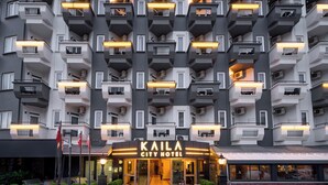 A multi-story hotel with balconies, a well-lit entrance, and a clear sign reading "KAILA CITY HOTEL". - Kaila City Hotel (Alanya)