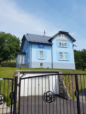 A two-story building with a blue exterior and a sign that reads "Blue Pension". - Blue Pension (Svoboda nad Upou)