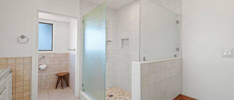 A modern bathroom with a shower, a toilet, and a sink.