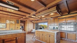 A spacious kitchen with wooden cabinetry, a large island, and stainless steel appliances. - Capurro Ranch at Moss Landing - Moss Landing House - 5BR with cottage at Elkhorn Slough (Moss Landing)