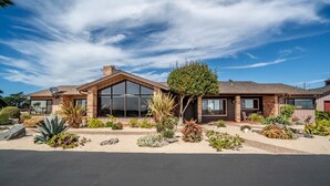 A modern house with a large glass window, a brick exterior, and a landscaped garden with various plants. - Capurro Ranch at Moss Landing - Moss Landing House - 5BR with cottage at Elkhorn Slough (Moss Landing)