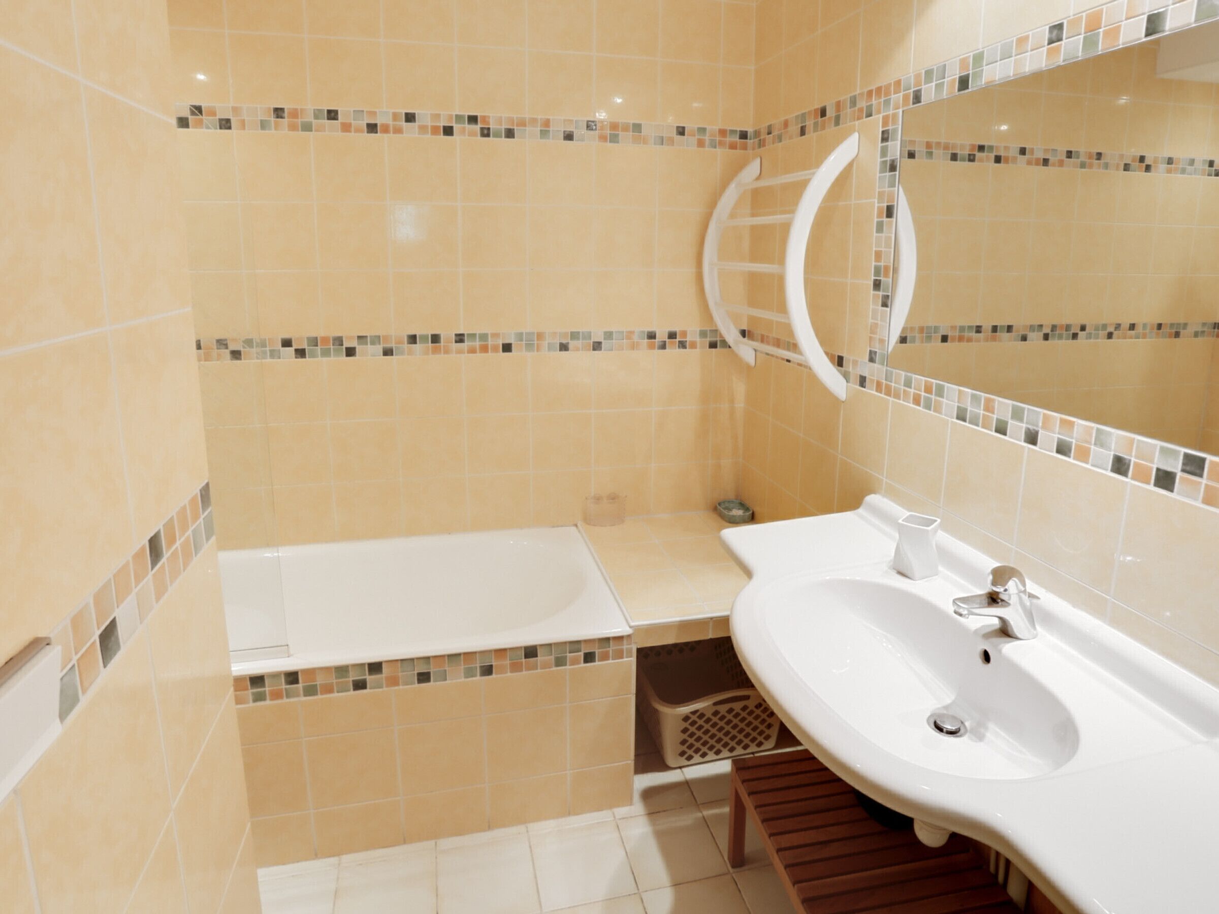 A bathroom with a white sink, mirror, and a shower area.