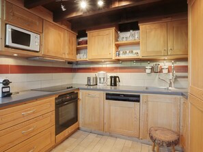 A modern kitchen with wooden cabinets, a microwave, a coffee maker, and a dishwasher. - 5-room duplex for 10 people in Méribel, pets allowed (Méribel)
