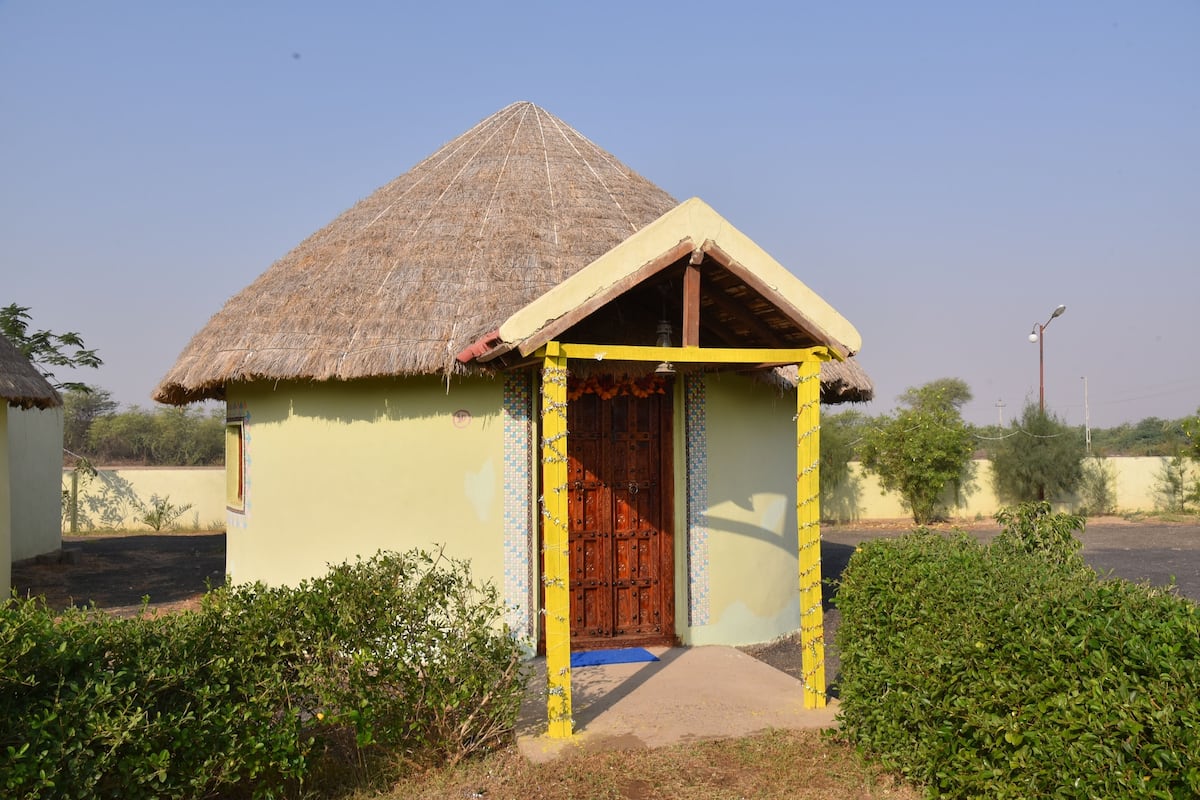 A small, single-story building with a thatched roof and a wooden door.