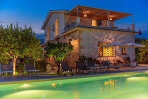 A two-story building with a pool, outdoor seating, and a covered patio area. - Tenuta Don Paolino (Avola)