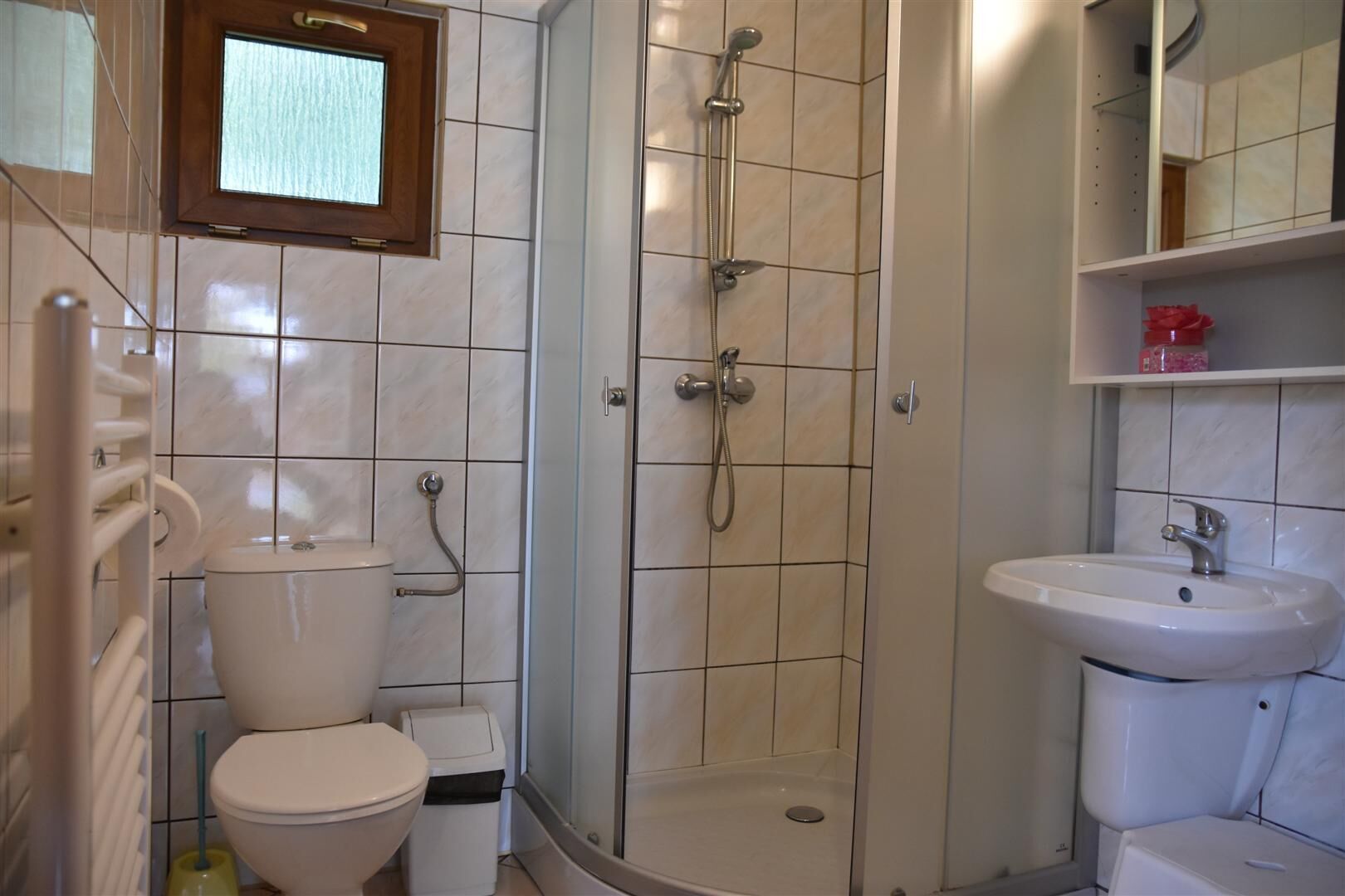 A bathroom with a toilet, a shower enclosure, and a sink.
