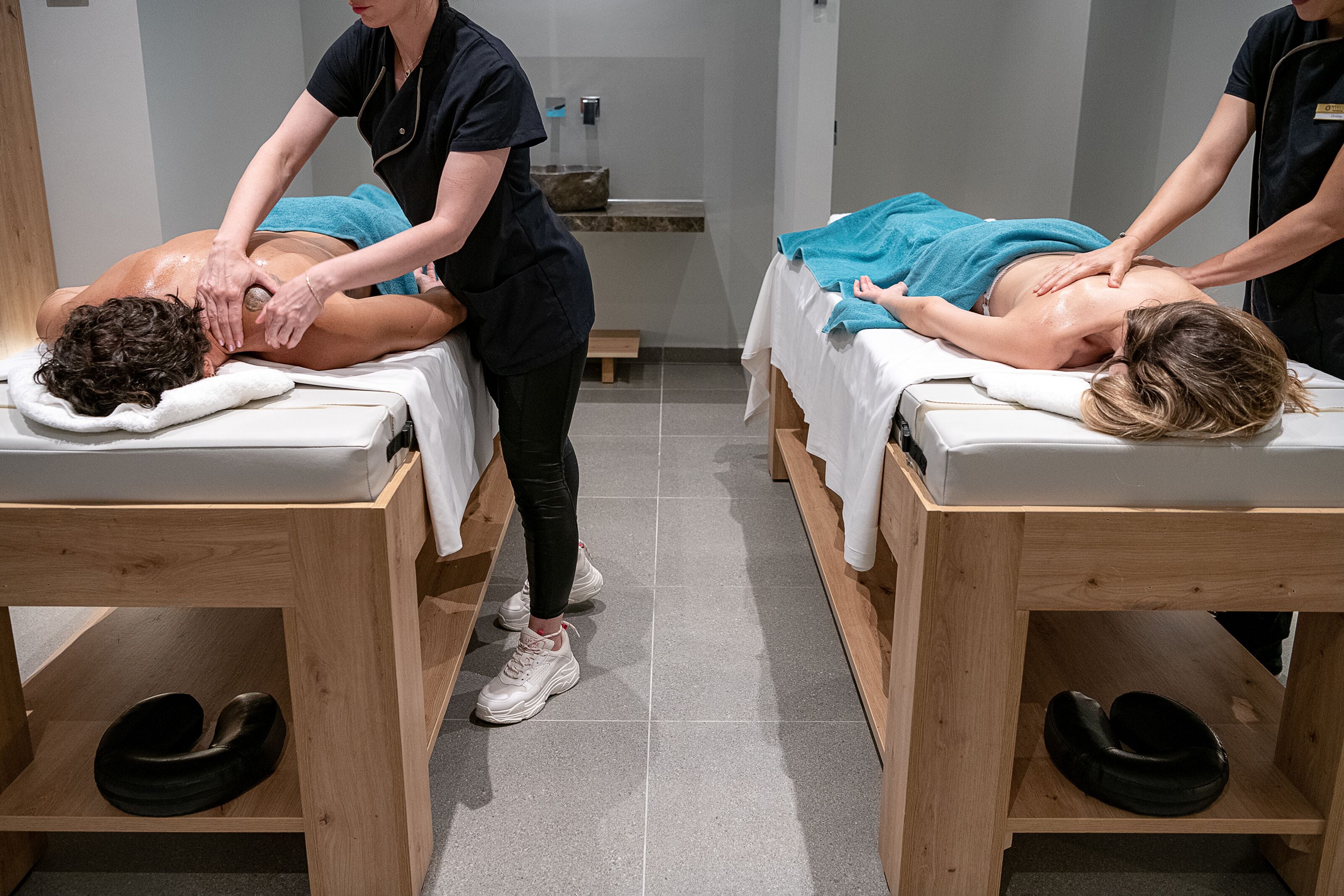 A massage therapy room with two clients receiving back massages.