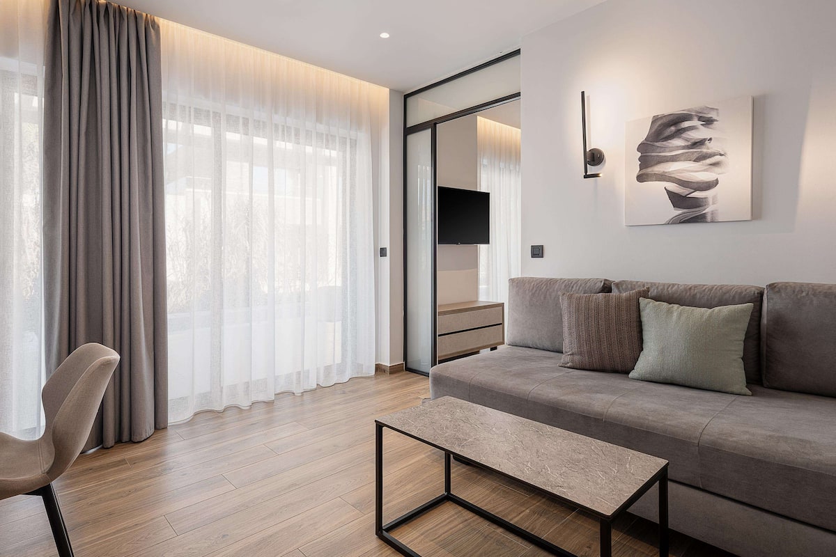 A modern living room with a sofa, a coffee table, and a chair.
