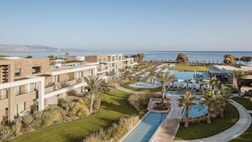 A resort with multiple buildings, a swimming pool, and a view of the ocean.