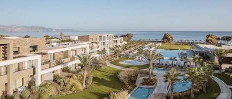 Un resort con varias edificaciones, una piscina y vistas al océano.