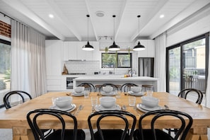 A modern kitchen with white cabinetry, a central island, and pendant lighting. - Sorrento Beach House (Sorrento)