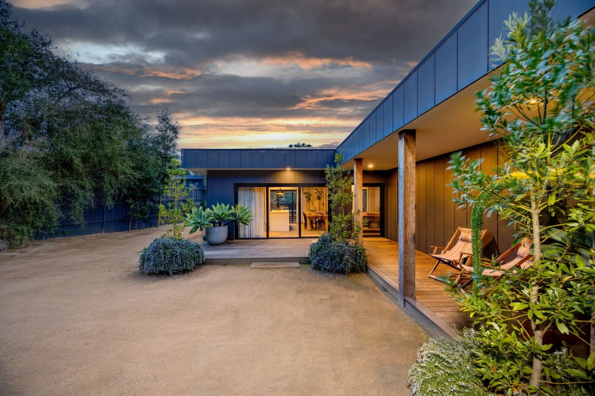 A modern building with a covered patio, outdoor seating, and a view of the sky.