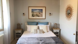 A bedroom with a bed, two bedside tables, a framed picture on the wall, and a decorative mirror on the right. - Le clos de la Barre, close to the sea. Ideal for recharging your batteries and visiting (Basly)
