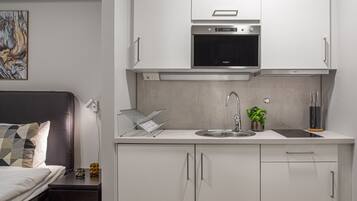 A modern kitchen with white cabinets, a stainless steel oven, and a sink.